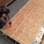 Arbeiter von oben mit HoloLens 2 mit einem Werkzeug an einer Spanplatte, darauf digitale Markierungen